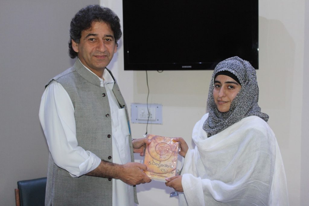 Kayenat Hameed presenting her book to the KP Minister of Culture & Tourism